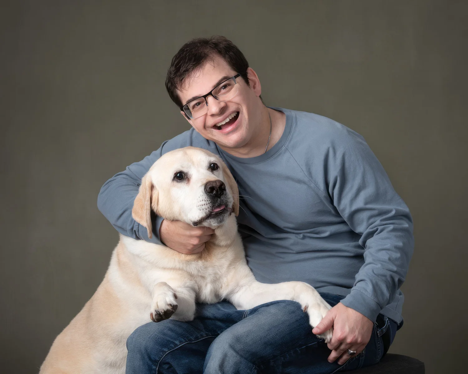 Ryan and Pico pose for the camera. Pico’s paws rest on Ryan’s lap.