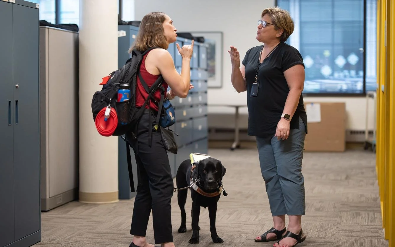 With her guide dog Paul at her side, Maya Larson signs with her boss Darlene Zangara, executive director of the Minnesota Commission of the Deaf, Deafblind and Hard of Hearing in St. Paul, Minn. (Glen Stubbe/Star Tribune/TNS)