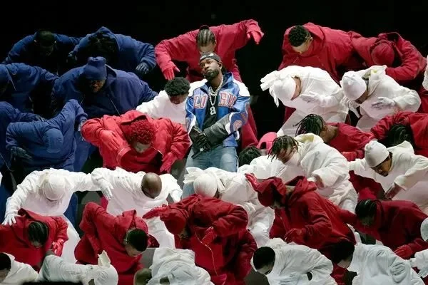 Kendrick Lamar performs at the Super Bowl XIL Halftime Show in New Orleans, February 9, 2025. He is surrounded by dancers dressed in red, white, and blue.